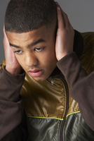 Teenage boy covering his ears with his hands